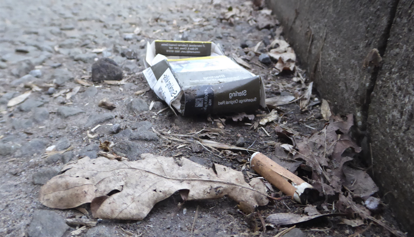 A discarded cigarette and packets on a street
