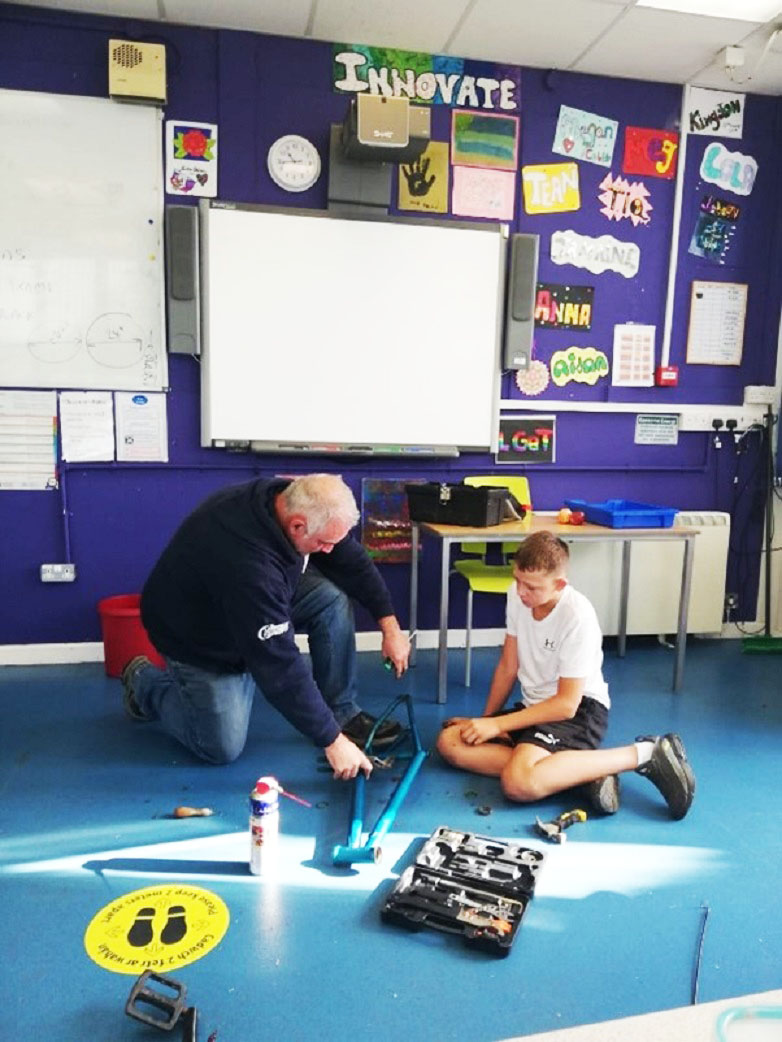 Dau berson ar y ddaear gydag offer adeiladu.