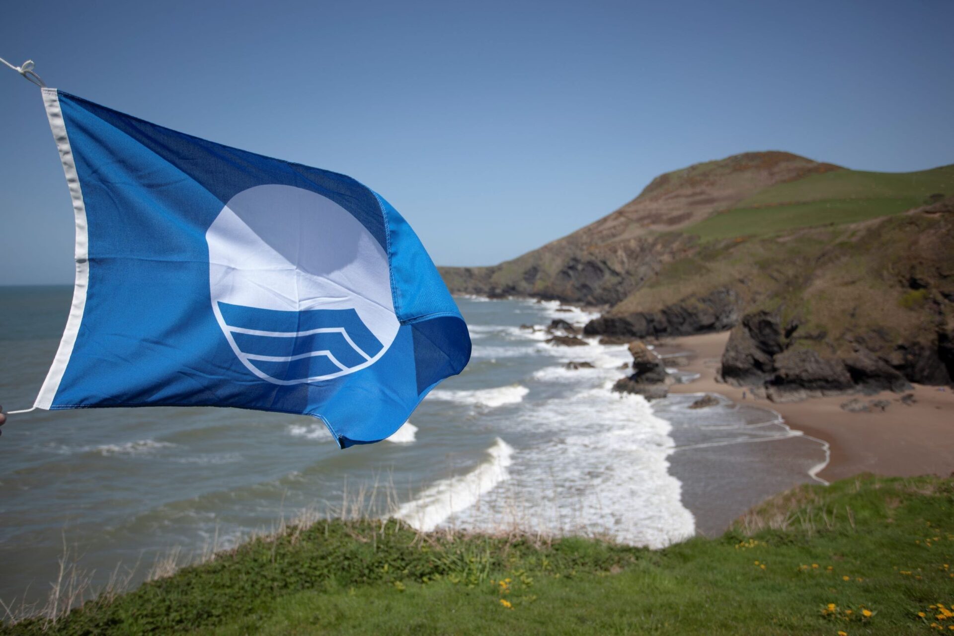 The iconic Blue Flag flying over a Ceredigion beach