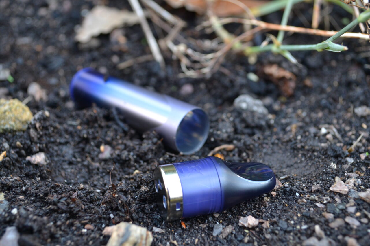 A close-up of a single-use vape littered on a street