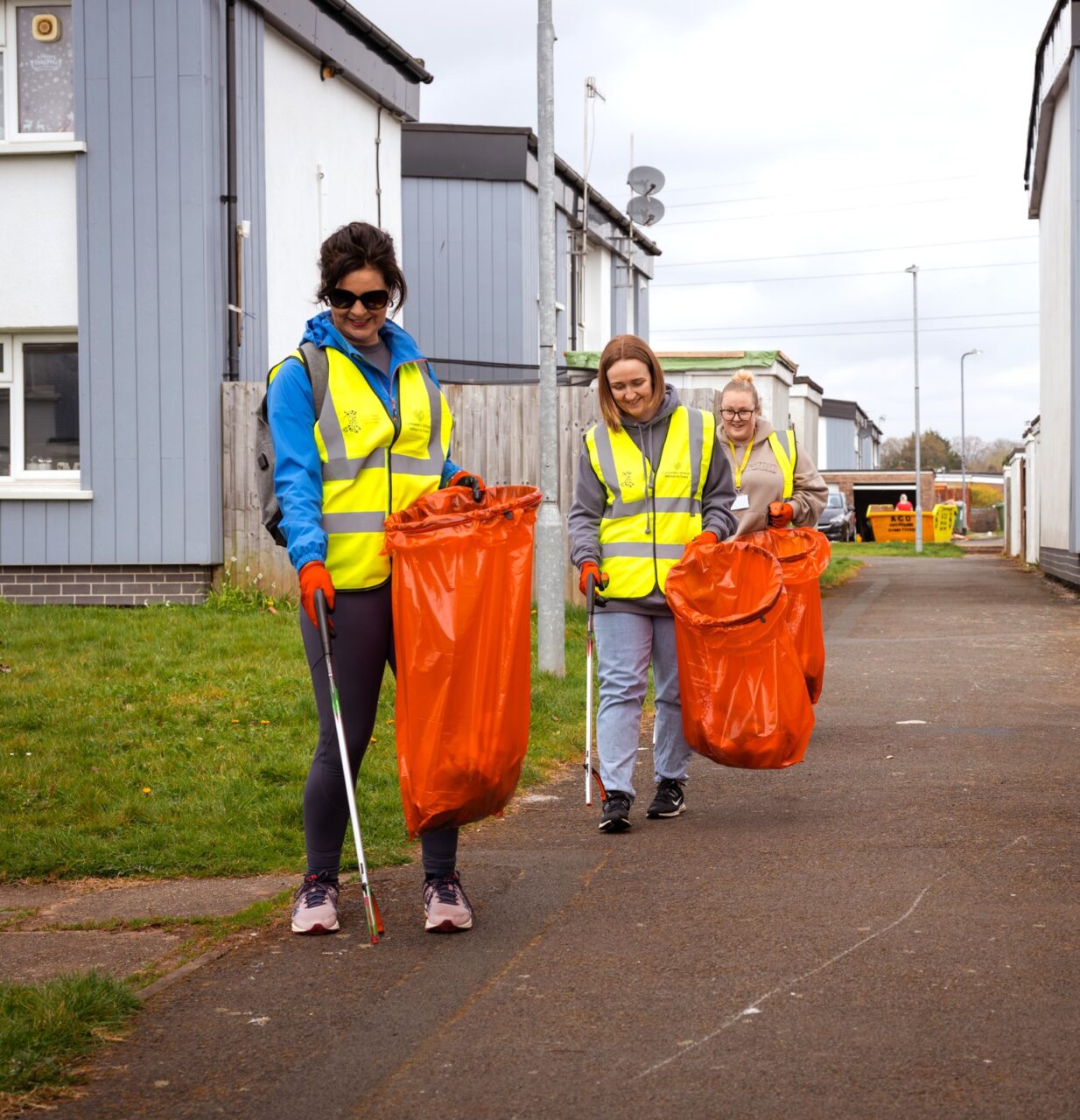 Three staff volunteers collecting litter