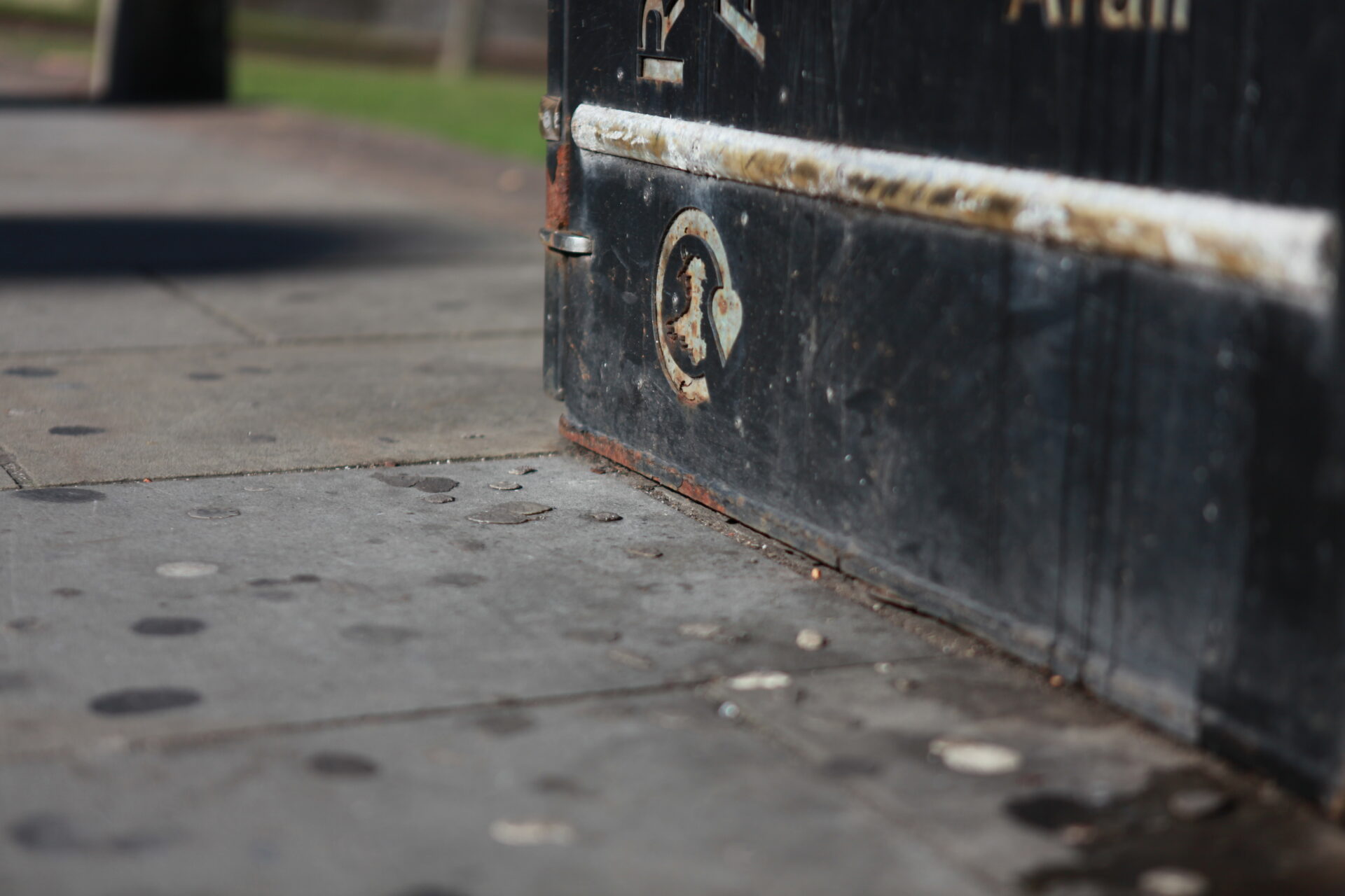 Chewing gum staining on a pavement next to a bin