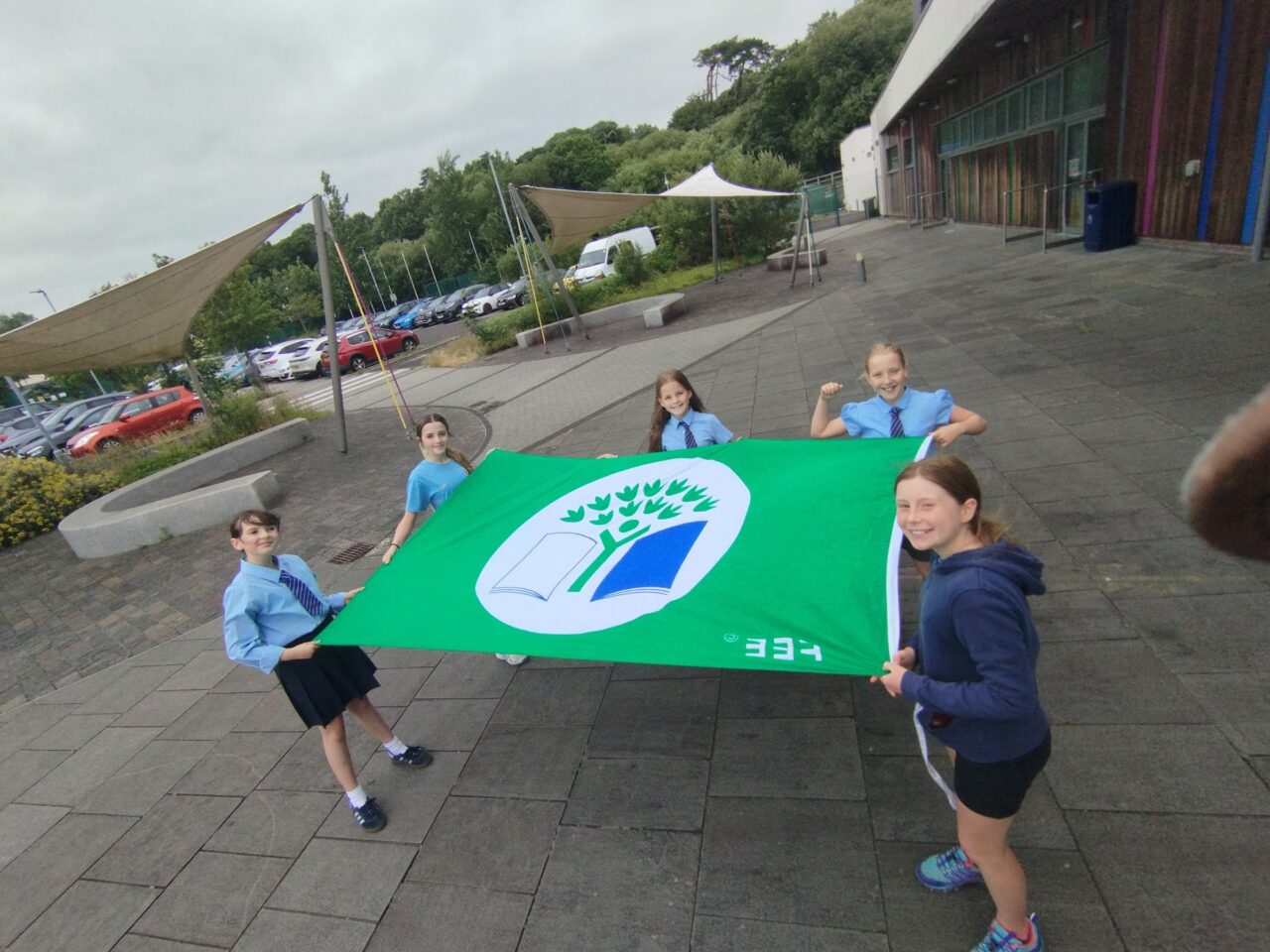 Group of learners holding a Eco-Schools green flag.