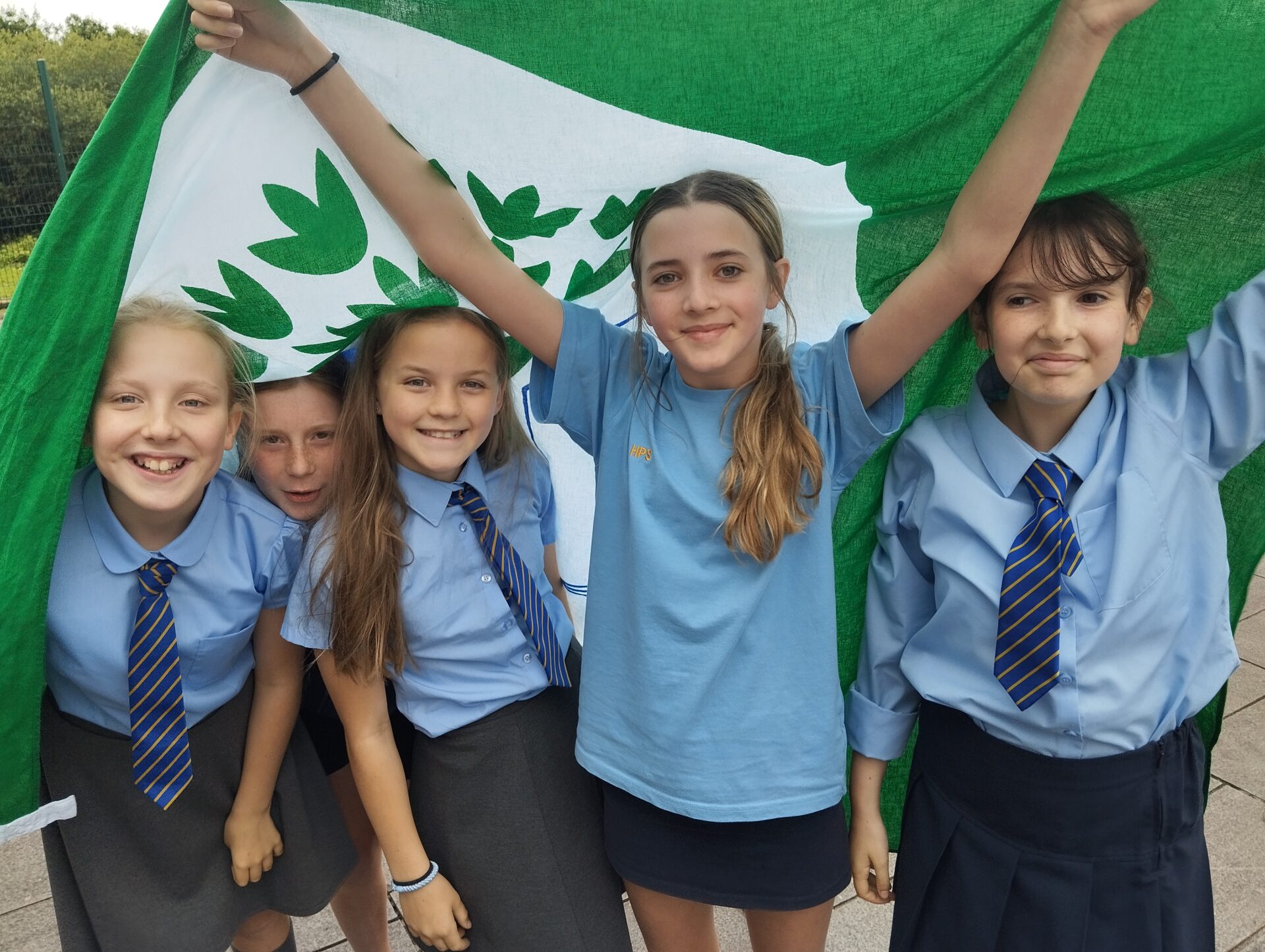 Group of learners holding a Eco-Schools green flag.